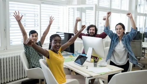 Diverse group of professionals cheering at office