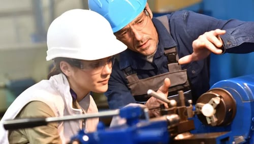 A man and woman collaboratively operating a complex machine