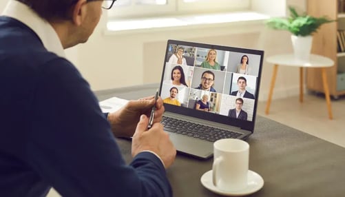 Male employee facing laptop screen on virtual meeting 