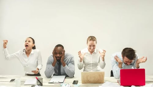 Professionals with different reactions while sitting in front of their computers