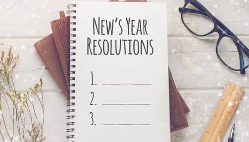 Notebook with 'New Year's Resolutions' listed, ready to be filled