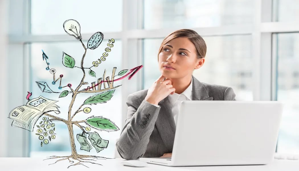 A woman working on a laptop and thinking about how to make her business grow with a drawing of growth in a metaphorical way