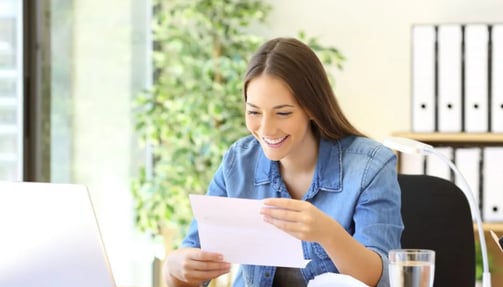 Woman reading a letter at her desk 