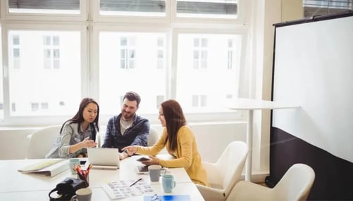 A team of professionals sitting together at a table with laptops, likely working on a project